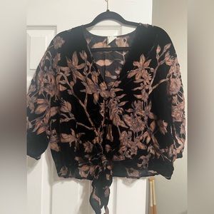 Black crop top with a tie front. Where the flowers are, it is see through.